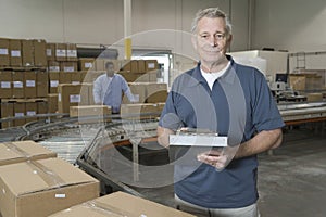 Portrait Of Man With Worker Behind At Warehouse