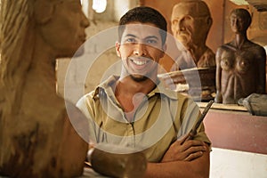 Portrait man working happy artist art wood sculpture in atelier