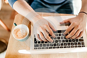 Portrait of man working from outdoor office.Freelancer typing on laptop in cafe place