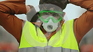 Portrait man yellow vest. Gas mask. Wearing a gasmask. Worker on strike in city.