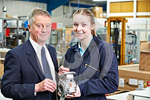 Portrait Of Manager And Apprentice Engineer Inspecting Component