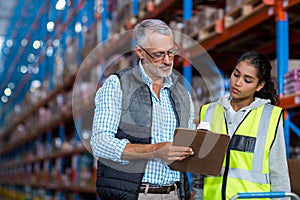 Portrait of manager is showing a clipboard to a worker