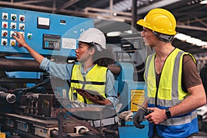 A portrait of a manufacturing worker in discussion with an industrial man and woman engineer holding a tablet in a factory. A