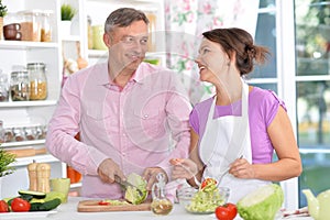 Portrait of married couple cooking at kitchen photo
