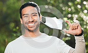 Portrait, mask and remove with a man breathing fresh air in nature, feeling happy at the end of restrictions. Covid