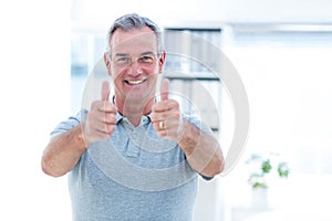 Portrait of masseur showing thumps sign