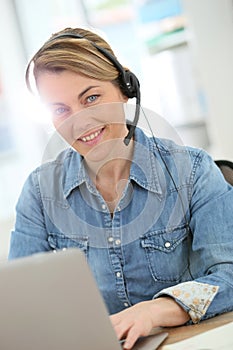 Portrait of mature active woman on laptop working