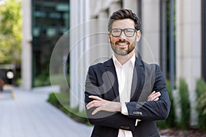 Portrait of mature adult businessman, senior boss with beard smiling and looking at camera, experienced and successful