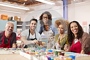 Portrait Of Mature Adults Attending Art Class In Community Centre With Teacher