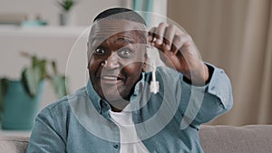 Portrait mature african american male happy homeowner showing keys to new apartment smiling looking at camera realtor