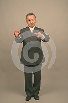 Portrait of mature Asian businessman with apple