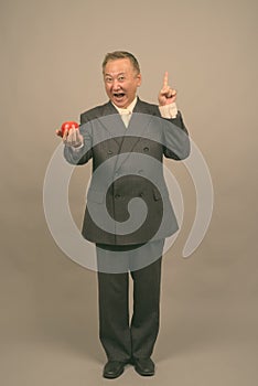 Portrait of mature Asian businessman with apple