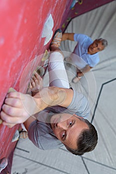 Portrait mature athlete on extreme climbing wall
