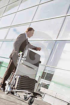 Portrait of mature businessman checking time on his watch while waiting in the airport