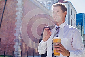 Portrait of mature businessman walking while holding a cup of coffee