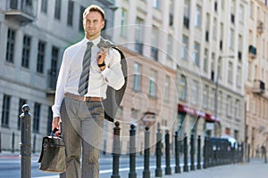 Portrait of mature businessman walking on pavement after work