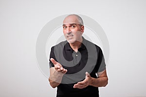 Portrait of mature caucasian a young man surprised and asking questions with hand raised. photo