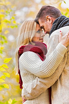 Portrait of Mature couple enjoying autumn while  showing affection in park