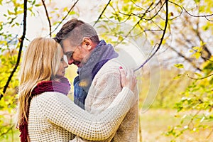 Portrait of Mature couple enjoying autumn while  showing affection in park