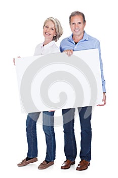 Portrait of mature couple holding placard