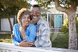 Portrait Of Mature Couple Looking Over Back Yard Fence