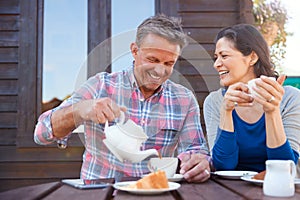 Portrait Of Mature Couple Sitting On Bench In Cafe Whilst Visiting Garden Center