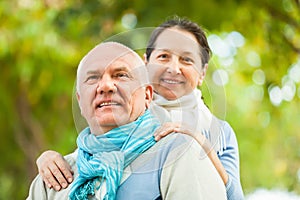 Portrait of mature couple in sweaters in a park