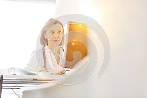 Portrait of mature doctor looking at patient medical result on her computer in clinic