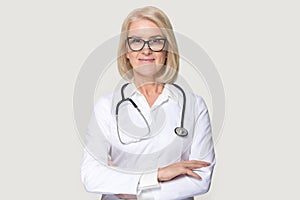 Portrait of mature female doctor isolated on grey background