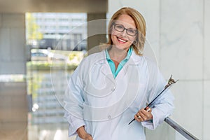 Portrait of a mature female medical staff doctor at hospital, genuine warm smile, qualified practitioner, experienced physician