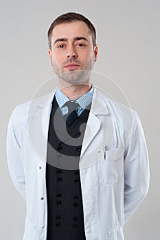 Portrait of mature male doctor on grey background.