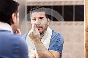 Portrait of mature man applying anti aging cream under eyes photo