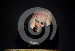 Portrait of mature man enfolded his head with palms