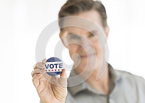 Portrait Of Mature Man Holding Vote Button