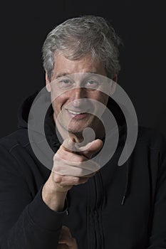 portrait of a mature man pointing his finger in a low key image
