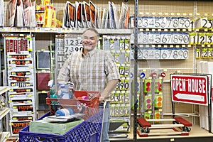 Portrait of a mature man with shopping cart in hardware store