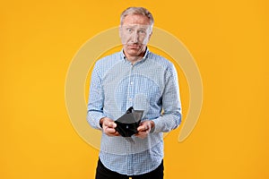 Portrait of mature man showing his empty wallet