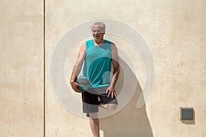 portrait of mature man on street basketball court against a wall