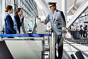 Portrait of mature pilot talking with the airport staffs in boarding gate photo