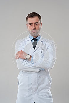 Portrait of mature serious male doctor with crossed arms