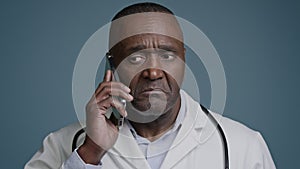 Portrait mature serious man talking on mobile phone focused puzzled confused professional doctor pediatrician therapist