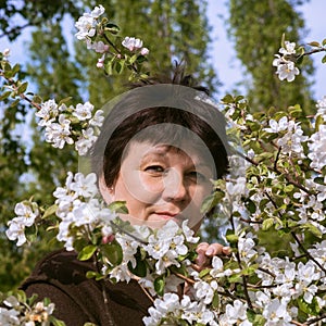 Portrait of mature woman among apple tree