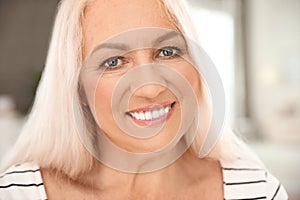 Portrait of mature woman with beautiful face on background, closeup view