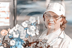 Portrait of a mature woman with flowers in the park