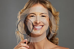 Portrait of a mature woman, magnifying beauty of skin and natural healthy skincare routine on gray background studio