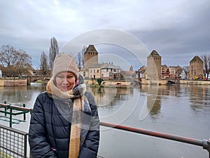 Portrait of mature woman at the medieval bridge Ponts Couverts and barrage Vauban, evening scene of Strasbourg