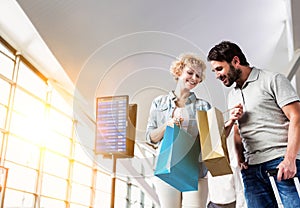 Portrait of mature woman showing present she bought in duty free with her husband at airport photo