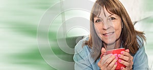 Portrait of mature woman smiling and holding a mug