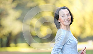 Portrait of mature woman weared in sports clothes in the park