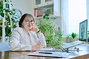 Portrait of mature woman working at home on computer laptop